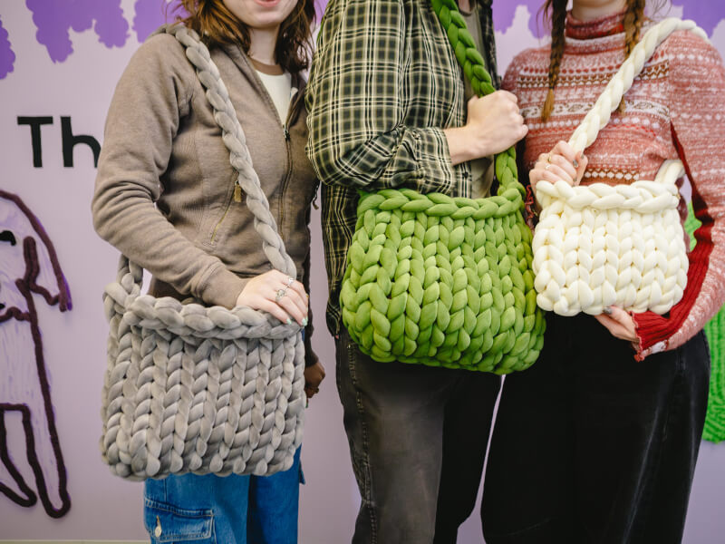 People showing off their handmade bags